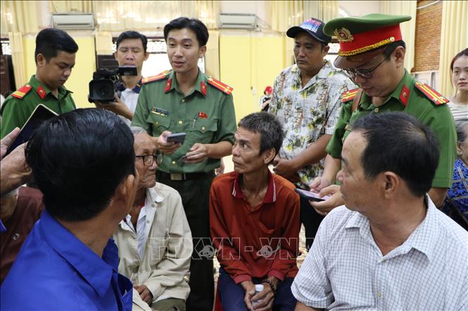 Cán bộ, chiến sĩ Công an tỉnh Đồng Tháp hỗ trợ người dân cài đặt các ứng dụng chuyển đổi số. Ảnh: Hồng Thái - TTXVN
