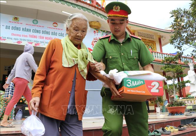 Chiến sĩ công an tỉnh Đồng Tháp hỗ trợ người dân tại chương trình. Ảnh: Hồng Thái - TTXVN