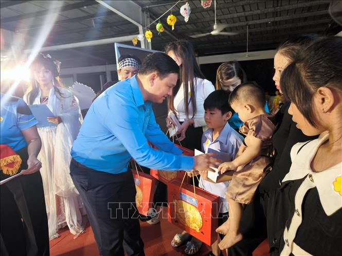 Tặng học bổng cho con công nhân lao động có hoàn cảnh khó khăn tại chương trình. Ảnh: Huỳnh Phúc Hậu - TTXVN