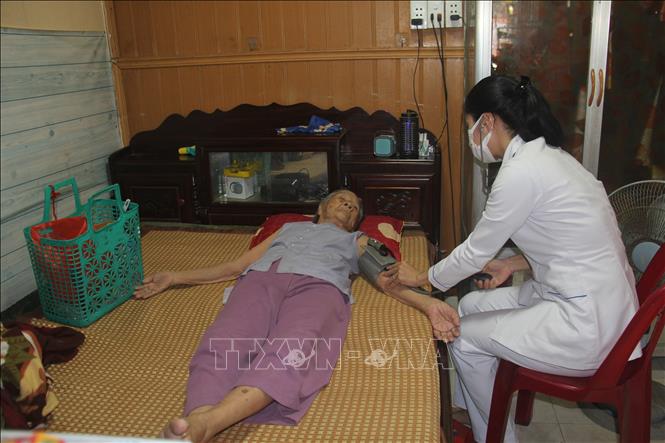 Những trường hợp người cao tuổi, người khuyết tật, người già neo đơn được nhân viên y tế đến tận nhà thăm khám. Ảnh: Mỹ Hà - TTXVN