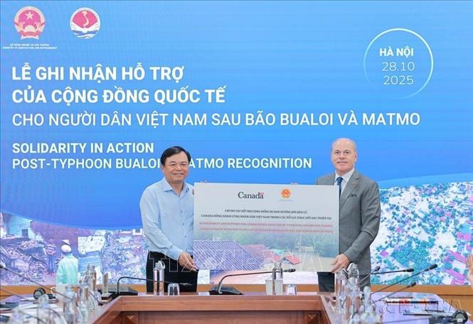 Ông Nguyễn Hoàng Hiệp, Thứ trưởng Bộ Nông nghiệp và Môi trường tiếp nhận hỗ trợ từ ông James Nickel, Đại sứ Canada tại Việt Nam tại Lễ ghi nhận của cộng đồng quốc tế cho người dân Việt Nam sau bão Bualoi và Matmo (Hà Nội, 28/10/2025). Ảnh: Lê Đông - TTXVN