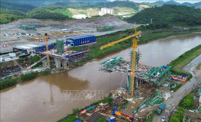 Hạng mục phần cầu chính phía Việt Nam (phải) được nhà thầu thi công vươn dần ra giữa sông Hồng, dự kiến sẽ được hợp long vào cuối năm nay. Ảnh: Quốc Khánh - TTXVN