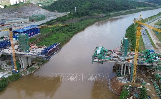 Hạng mục phần cầu chính phía Việt Nam (phải) được nhà thầu thi công vươn dần ra giữa sông Hồng, dự kiến sẽ được hợp long vào cuối năm nay. Ảnh: Quốc Khánh - TTXVN