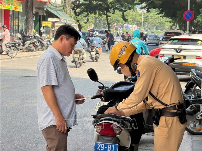 Lực lượng Cảnh sát giao thông kiểm tra xe hợp đồng trong đợt tăng cường xử lý phương tiện dừng, đỗ, đón trả khách không đúng quy định, sáng 21/9/2026. Ảnh: Trung Nguyên - TTXVN