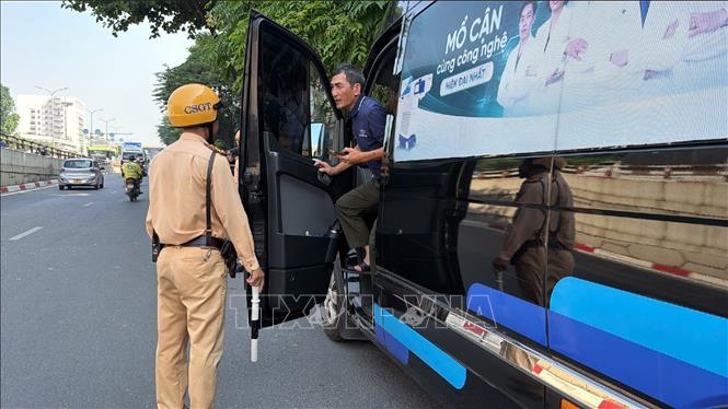 Lực lượng chức năng kiểm tra xe hợp đồng dừng bên đường trên tuyến Lê Duẩn - Giải Phóng, Hà Nội, sáng 21/9/2026. Ảnh: Trung Nguyên - TTXVN