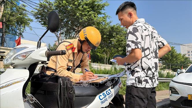 Cán bộ Đội Cảnh sát giao thông đường bộ số 4 lập biên bản trong quá trình kiểm tra, xử lý vi phạm trên tuyến Lê Duẩn - Giải Phóng, sáng 21/9/2026. Ảnh: Trung Nguyên - TTXVN