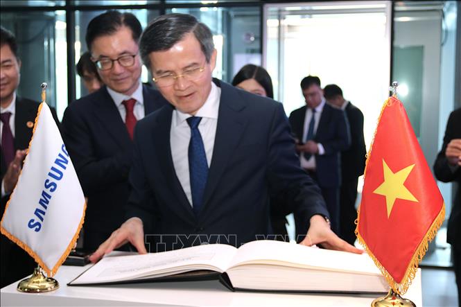 Đồng chí PGS, TS. Đoàn Minh Huấn, Ủy viên Bộ Chính trị, Giám đốc Học viện chính trị HCM ghi lưu bút tại Công ty Samsung Electronics. Ảnh: Khánh Vân -  PV TTXVN tại Hàn Quốc