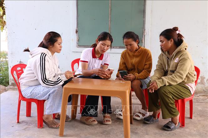 Thành viên Tổ công nghệ số cộng đồng “cầm tay chỉ việc” cho người dân. Ảnh: Đặng Tuấn - TTXVN.