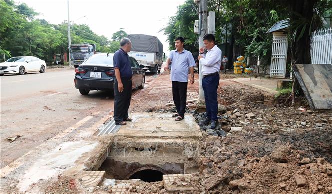 Đại diện đơn vị thi công, tư vấn giám sát trao đổi với người dân tại vị trí hố thu nước được cải tạo trên tuyến đường Tôn Đức Thắng, phường Bình Phước, thành phố Đồng Nai. Ảnh: Đậu Tất Thành – TTXVN