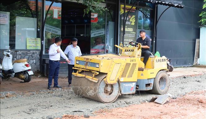 Đại diện đơn vị thi công và tư vấn giám sát trao đổi, kiểm tra việc lu lèn nền đường trong quá trình thi công hệ thống thoát nước trên đường Tôn Đức Thắng, phường Bình Phước, thành phố Đồng Nai. Ảnh: Đậu Tất Thành – TTXVN
