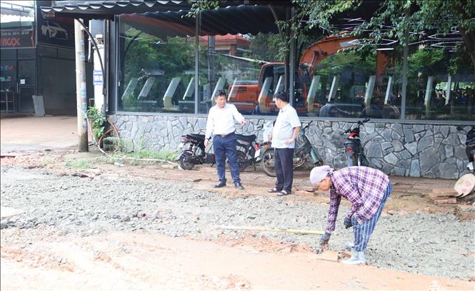 Đại diện đơn vị thi công và tư vấn giám sát kiểm tra thực tế hạng mục đang triển khai, bảo đảm tiến độ và chất lượng công trình thoát nước trên đường Tôn Đức Thắng, phường Bình Phước, thành phố Đồng Nai. Ảnh: Đậu Tất Thành – TTXVN