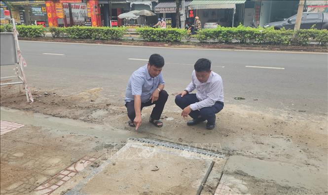 Đại diện đơn vị thi công và tư vấn giám sát kiểm tra vị trí hố thu nước trên tuyến đường Phú Riềng Đỏ, phường Bình Phước, thành phố Đồng Nai. Ảnh: Đậu Tất Thành – TTXVN