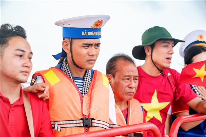 Hai cha con chiến sĩ Phạm Hồng Đức Anh cùng các nghệ sĩ trong đoàn đại biểu Thành phố Hồ Chí Minh đến thăm nhà giàn DKI/10. Ảnh: Xuân Anh – TTXVN