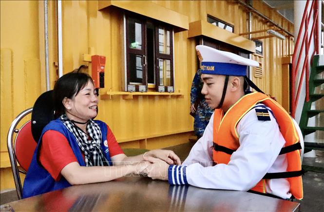 Hai mẹ con chiến sĩ Nguyễn Phạm Nhật Khương tranh thủ khoảng thời gian ít ỏi để hỏi han về sức khoẻ và công việc tại nhà giàn DKI/10. Ảnh: Xuân Anh – TTXVN