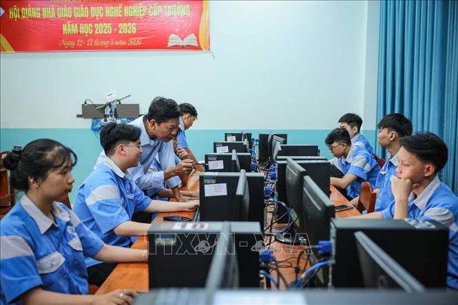 Thạc sĩ Đàm Quang Viễn - giảng viên khoa Công nghệ thông tin hướng dẫn sinh viên thực hành. Ảnh: Hoàng Hiếu – TTXVN