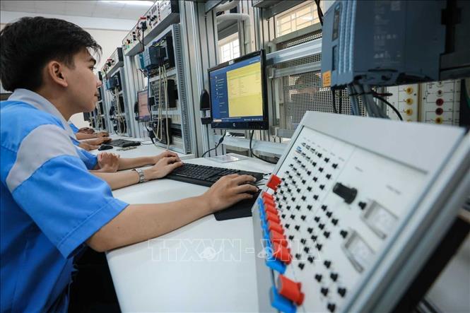 Sinh viên nghề Điện tử công nghiệp lập trình PLC. Ảnh: Hoàng Hiếu - TTXVN