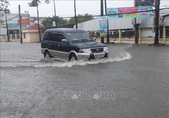 Xe ô tô di chuyển qua tuyến đường trung tâm tỉnh Cà Mau ngập sâu trong nước. Ảnh: Tuấn Phi - TTXVN
