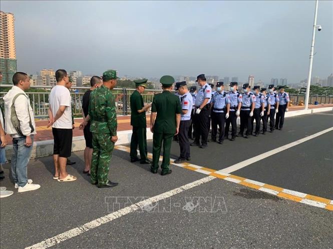 Các công dân Trung Quốc vi phạm pháp luật Việt Nam được bàn giao cho cơ quan chức năng Trung Quốc. Ảnh: TTXVN phát