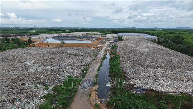 Hố chôn rác đã đầy, nước rỉ rác tràn ra đường công vụ. Cao Nguyên - TTXVN
