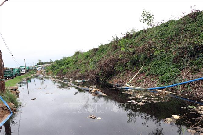 Nước rỉ rác chảy tràn ra đường đi, làm ảnh hưởng đến môi trường và việc vận chuyển, xử lý rác. Ảnh: Cao Nguyên - TTXVN
