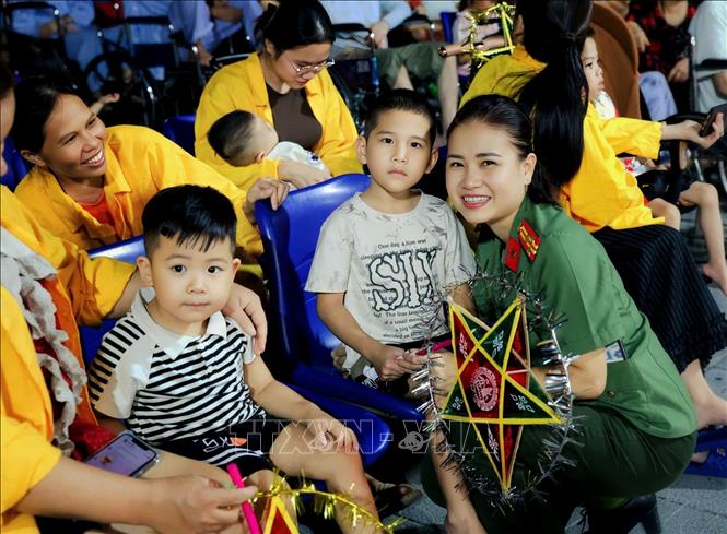 Chiến sĩ công an Bắc Ninh chung vui cùng các cháu nhỏ. Ảnh: Danh Lam -TTXVN