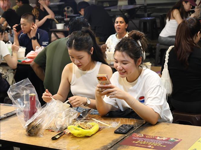 Thực khách thưởng thức các món ăn ngay tại khu vực ăn uống của chợ đêm. Ảnh: Thanh Bình – PV TTXVN tại Malaysia