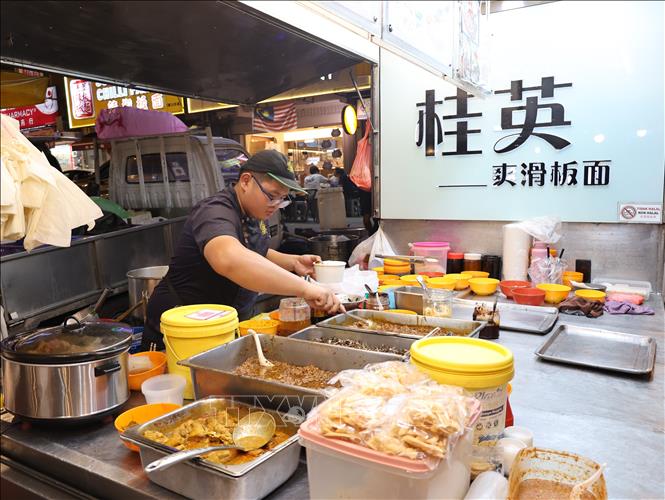 Người bán chuẩn bị món mì với nhiều loại gia vị đặc trưng trong văn hóa người Hoa ở chợ đêm Malaysia. Ảnh: Thanh Bình – PV TTXVN tại Malaysia