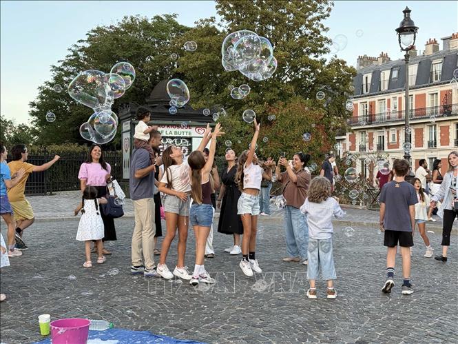 Du khách thích thú với màn biểu diễn bong bóng trên đồi Montmartre. Ảnh: Hữu Chiến - PV TTXVN tại Pháp