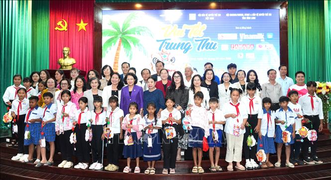 Các đại biểu và đơn vị đồng hành và các em học sinh chụp ảnh lưu niệm tại chương trình. Ảnh: Lê Thúy Hằng – TTXVN