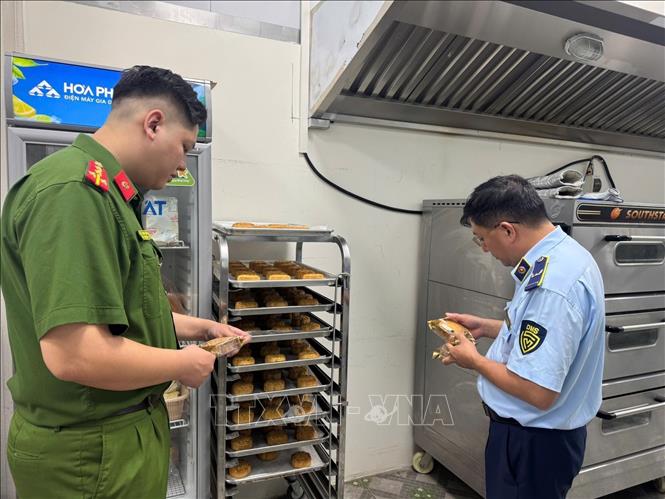 Lực lượng chức năng kiểm tra tại một cơ sở sản xuất bánh Trung thu. Ảnh: Quốc Lũy - TTXVN