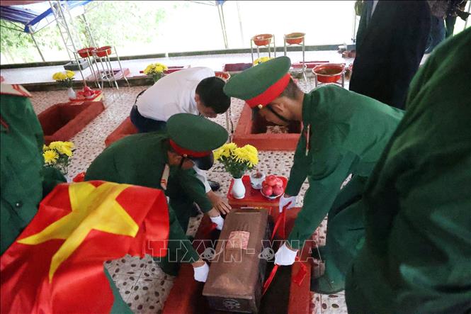Các đại biểu thực hiện nghi lễ an táng 45 hài cốt liệt sĩ tại nghĩa trang liệt sĩ Hòn Dung. Ảnh: Đặng Tuấn -TTXVN