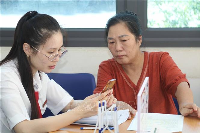 Cán bộ Agribank tỉnh Lạng Sơn hướng dẫn người dân thực hiện thủ tục hành chính trên các nền tảng số. Ảnh: Quang Duy – TTXVN