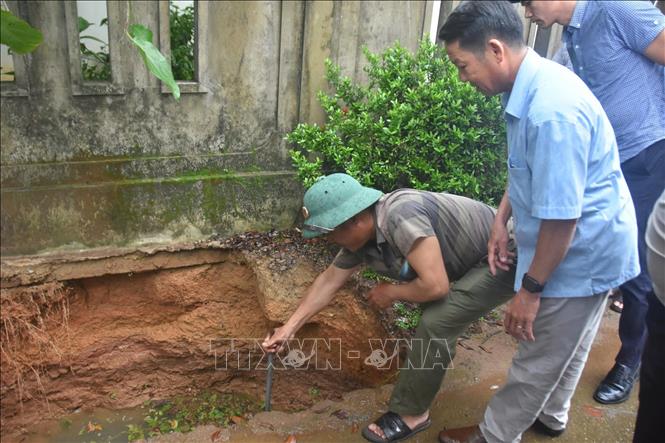Lực lượng chức năng kiểm tra, đánh giá tại hố sụt lún tại xã Hiếu Giang. Ảnh: TTXVN phát