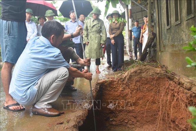 Các lực lượng chức năng kiểm tra, đánh giá tại hố sụt lún tại xã Hiếu Giang. Ảnh: TTXVN phát