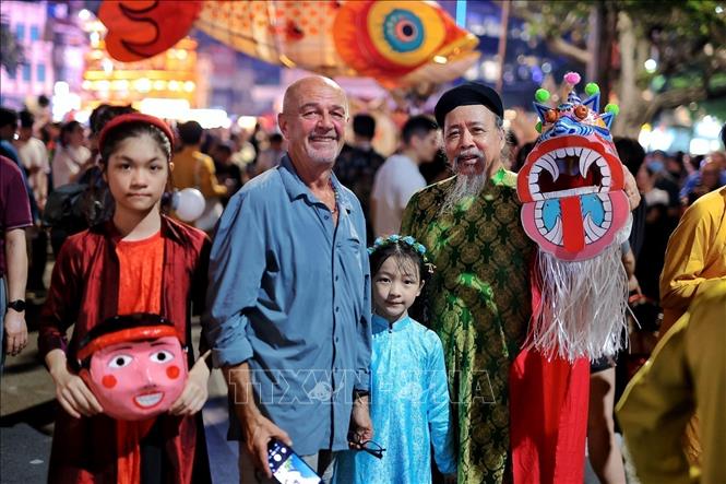 Foreign tourists join in the festive atmostphere on Hoan Kiem Lake, Hanoi. VNA Photo