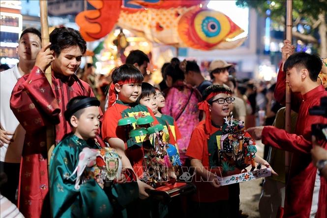 Children bring traditional toys to take part in the procession. VNA Photo