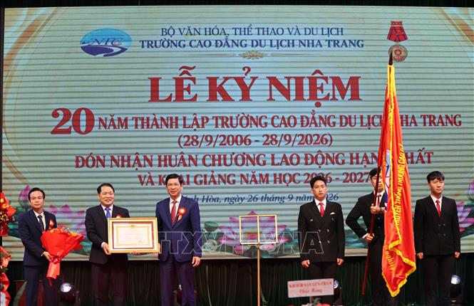 Đại diện Bộ Văn hóa, Thể thao và Du lịch, thừa uỷ quyền của Chủ tịch nước, trao Huân chương Lao động hạng Nhất cho Trường Cao đẳng Du lịch Nha Trang. Ảnh: Đặng Tuấn – TTXVN