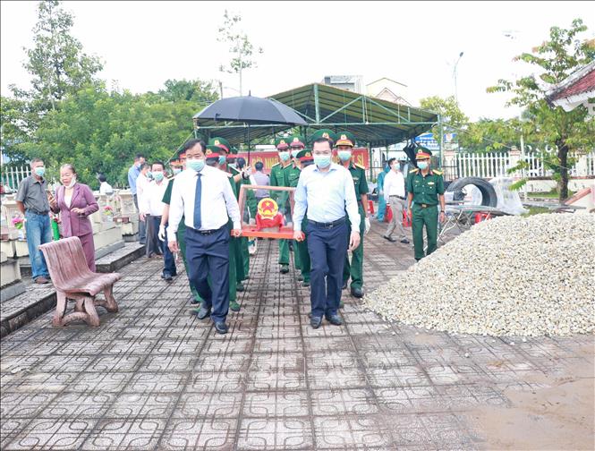 Phó Bí thư Tỉnh uỷ Cà Mau Huỳnh Quốc Việt (bìa trái) và Phó Chủ tịch UBND tỉnh Ngô Vũ Thăng cùng tổ vận chuyển đưa hài cốt liệt sĩ về nơi lấy mẫu sinh phẩm. Ảnh: Huỳnh Anh - TTXVN