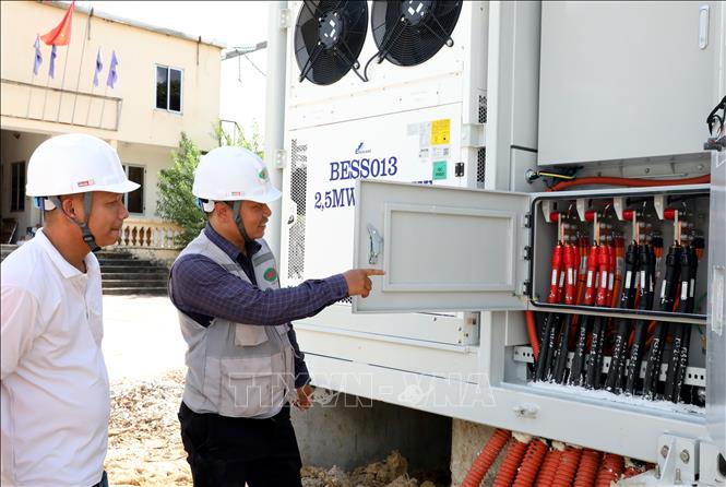 Đại diện các đơn vị liên quan kiểm tra các thiết bị thuộc hệ thống pin lưu trữ năng lượng trước khi đóng điện. Ảnh: Văn Đạt - TTXVN
