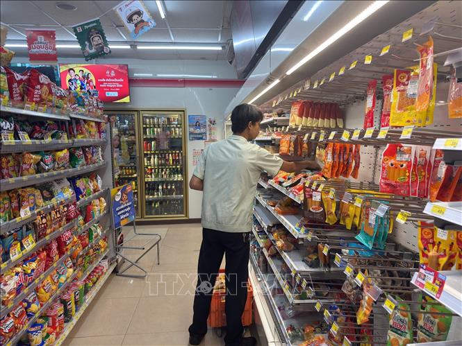 Nhân viên cửa hàng tiện lợi 7 Eleven ở khu Asok-Din Daeng, quận Din Daeng, Bangkok, tranh thủ xếp hàng mới về lên kệ. Ảnh: Trang Nhung - PV TTXVN tại Thái Lan