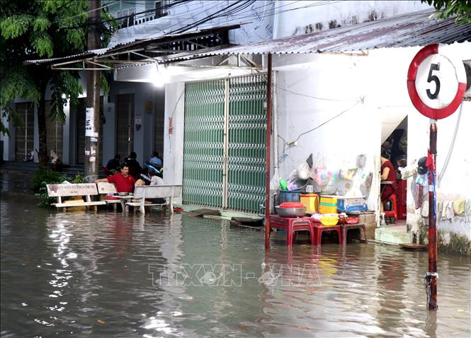 Mưa lớn kết hợp với triều cương gây ngập, ảnh hưởng việc đi lại và đời sống người dân. Ảnh: Lê Thúy Hằng – TTXVN 
