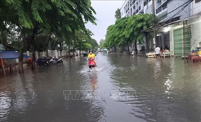 Mưa lớn kết hợp với triều cường gây ngập, ảnh hưởng việc đi lại và đời sống người dân. Ảnh: Lê Thúy Hằng – TTXVN. 
