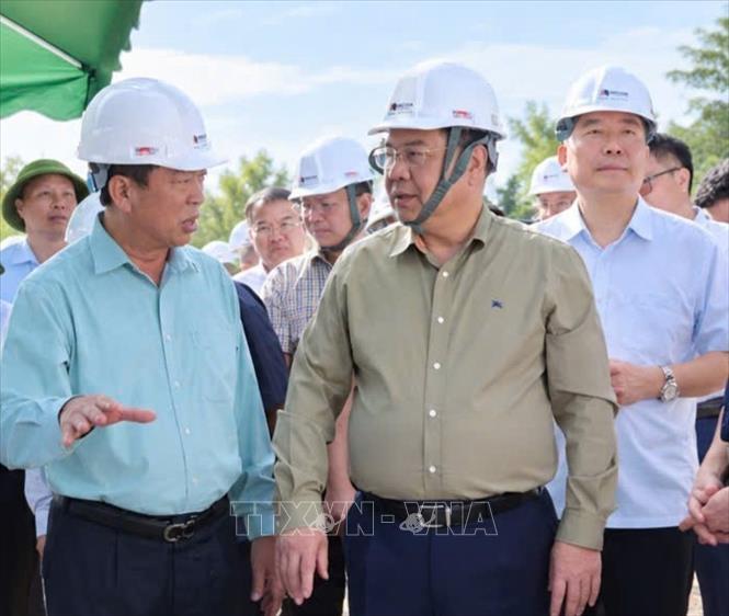 Phó Thủ tướng thường trực Phạm Gia Túc nghe đại diện nhà thầu báo cáo tiến độ thi công tại công trường. Ảnh: TTXVN phát