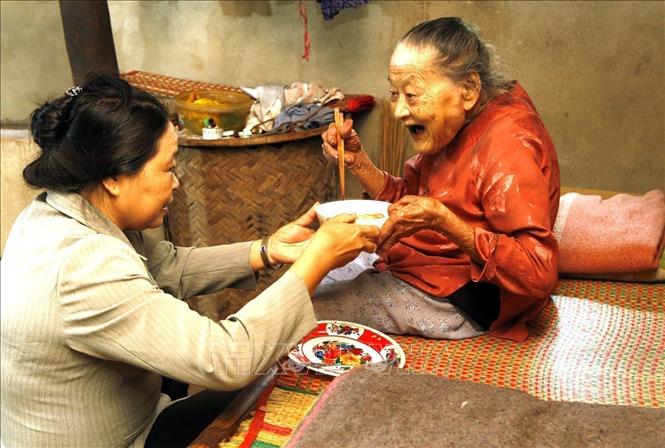 Cộng tác viên dân số hỗ trợ chăm sóc người cao tuổi có hoàn cảnh đặc biệt khó khăn tại huyện Hòa Vang, Đà Nẵng (2018). Ảnh: Dương Ngọc - TTXVN