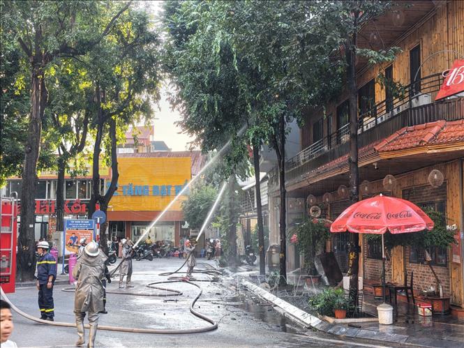 Lực lượng chức năng đang khẩn trương xử lý đám cháy, ngăn chặn ngọn lửa lây lan. Ảnh: Lê Đông - TTXVN