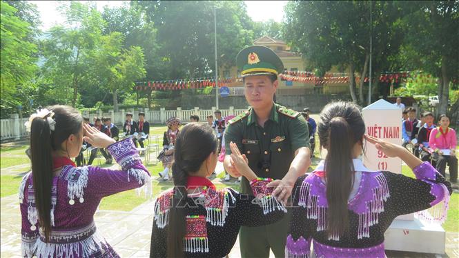 Hướng dẫn động tác chào cột mốc cho các học sinh. Ảnh: Hương Thu - TTXVN