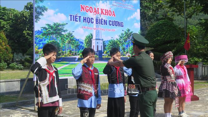 Hướng dẫn động tác chào cột mốc cho các học sinh. Ảnh: Hương Thu - TTXVN