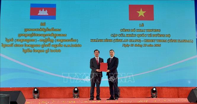 Ông Nguyễn Hoàng Hải, Phó Chủ nhiệm Ủy ban Biên giới quốc gia - Bộ Ngoại giao (bên phải) trao Nghị quyết của Chính phủ về việc phê duyệt nâng cấp Cửa khẩu chính Khánh Bình lên Cửa khẩu quốc tế đường bộ cho lãnh đạo tỉnh An Giang. Ảnh: Thanh Sang - TTXVN