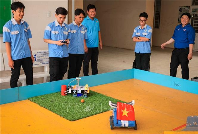 Sinh viên tích cực luyện tập, hiệu chỉnh hoàn thiện robot trên thực tế mô hình thi đấu robocon, với sự hỗ trợ chuyên môn của giảng viên khoa Điện tử. Ảnh: Hoàng Hiếu – TTXVN