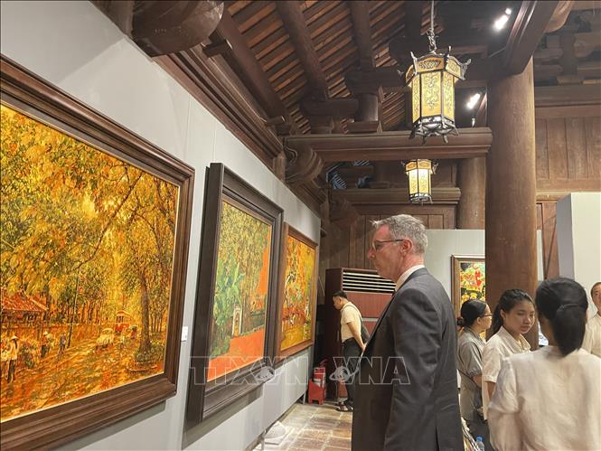 Du khách tham quan, tìm hiểu về tranh sơn mài đương đại tại triển lãm. Ảnh; Tuyết Mai - TTXVN
